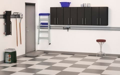 Garage interior with storage cabinets, a ladder, tools, and a checkered floor.