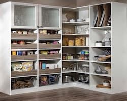 White kitchen pantry with shelves, drawers, and corner storage.