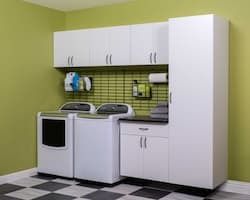 Laundry room with white cabinets, washer, dryer, and checkered floor. Green wall.