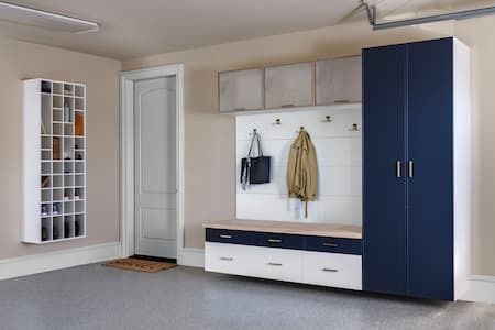 Garage organization system with shoe rack, cabinets, and bench in neutral colors.