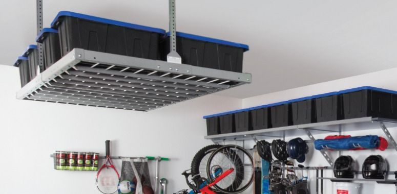 Garage storage with overhead and wall-mounted shelving holding bins and equipment.