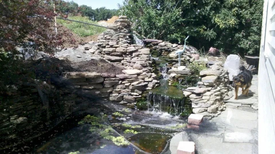A waterfall is being built in the backyard of a house
