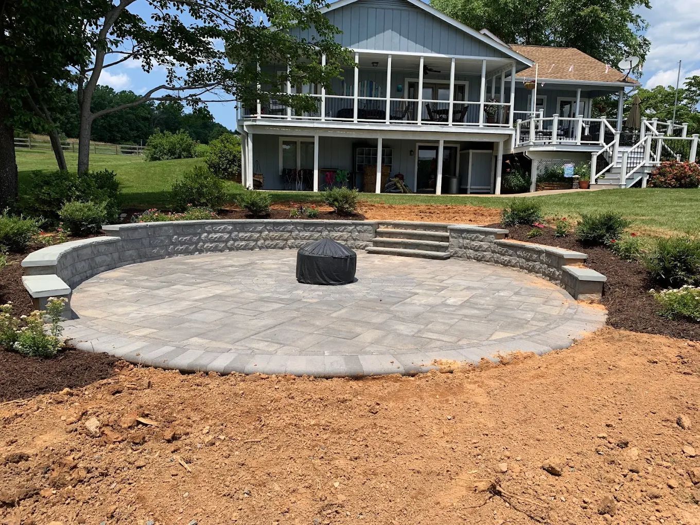A large house with a circular patio in front of it.