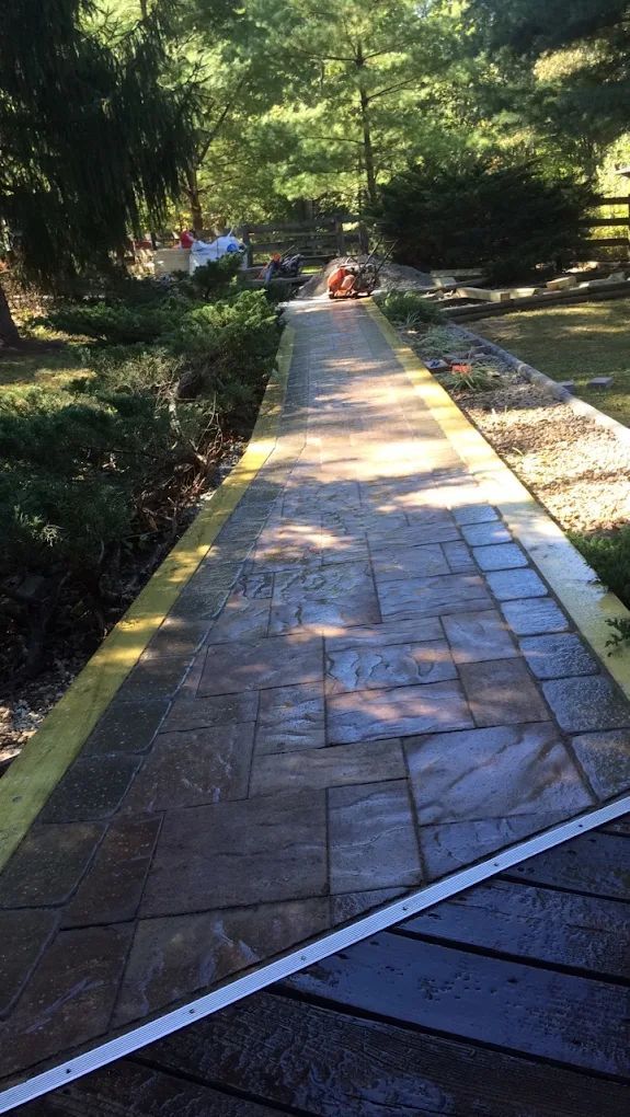 A brick walkway leading to a wooden deck in a park.