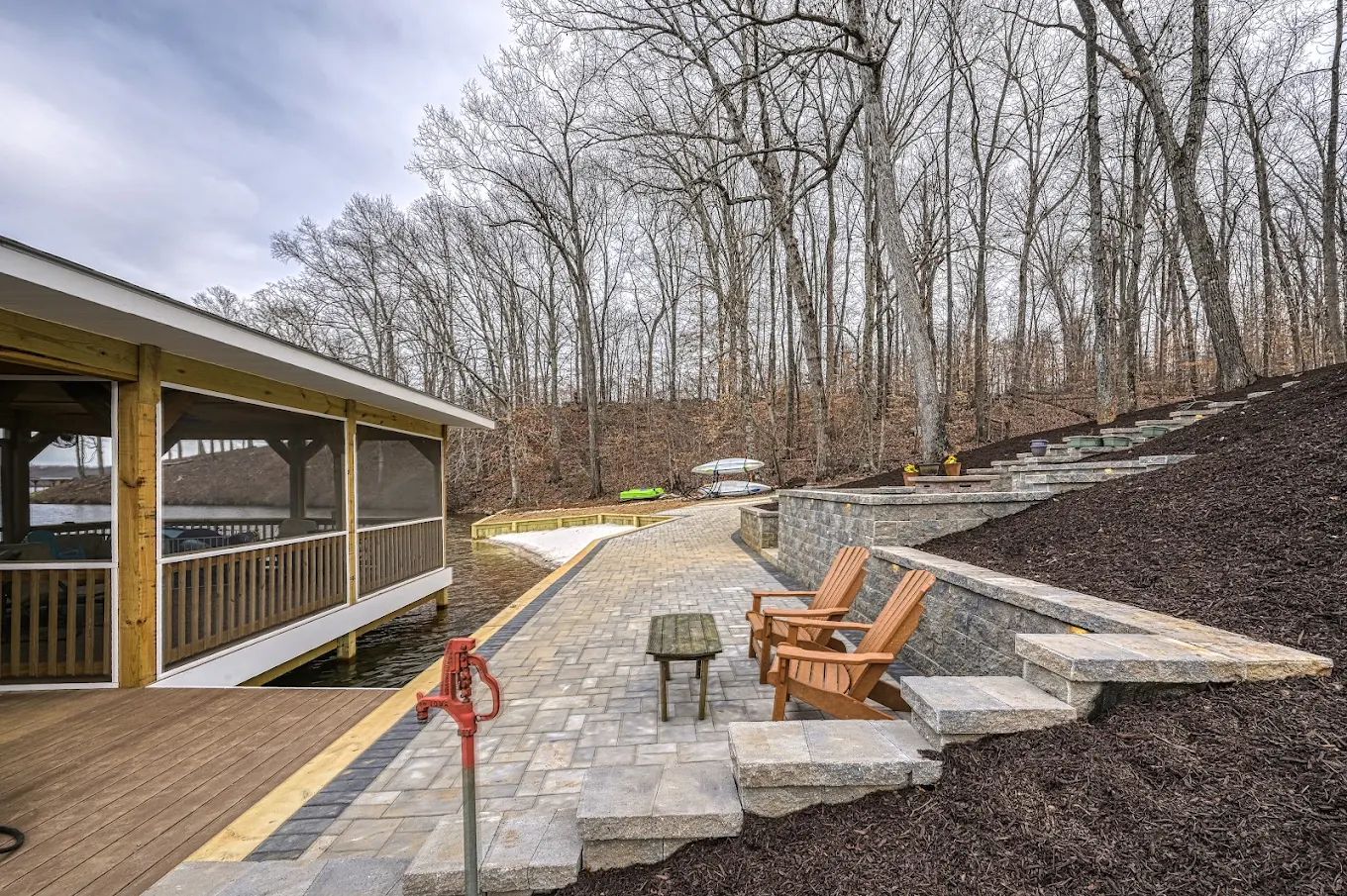 A patio with chairs , a table and a gazebo in the background.