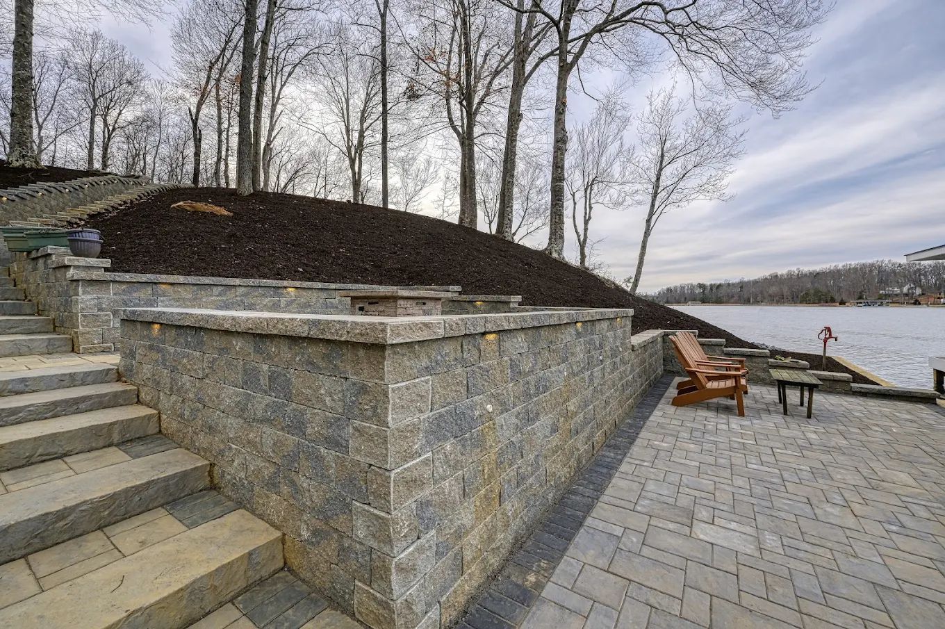 A brick wall with stairs leading up to a lake.