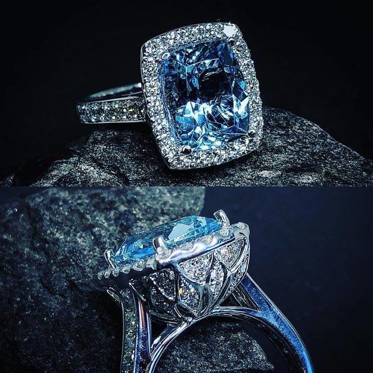 Two ornate diamond rings with large blue gemstones on a dark rock background