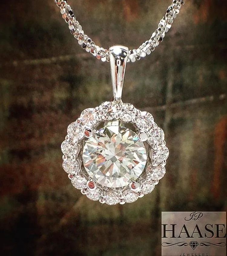 Diamond pendant necklace with a round center stone surrounded by a halo setting on a chain