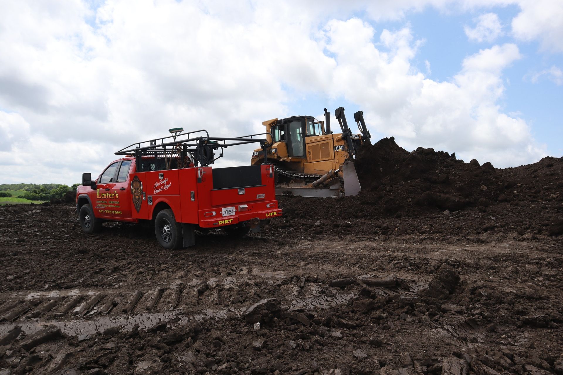 Red truck and bulldozer at a construction site.