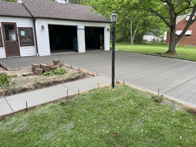 A concrete driveway is being built in front of a house.