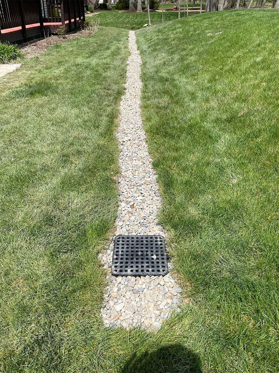 A gravel path going through a lush green field.
