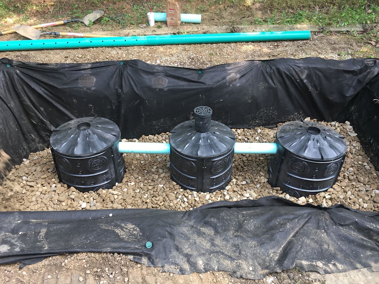 A septic system is being installed in a dirt field.