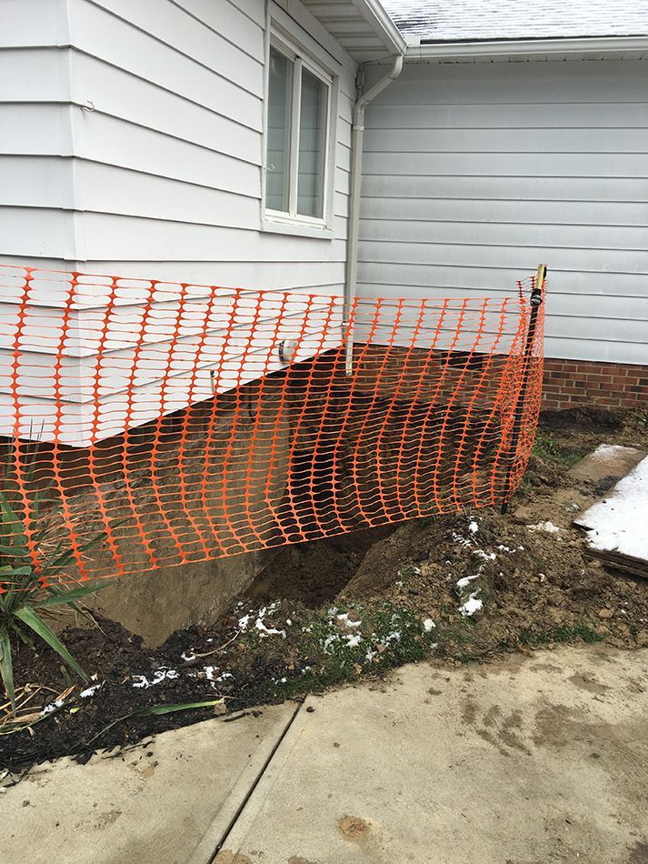 A white house with an orange fence around it.