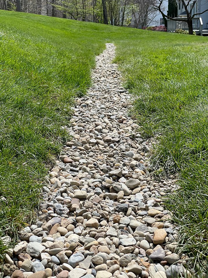 A gravel path going through a grassy field.