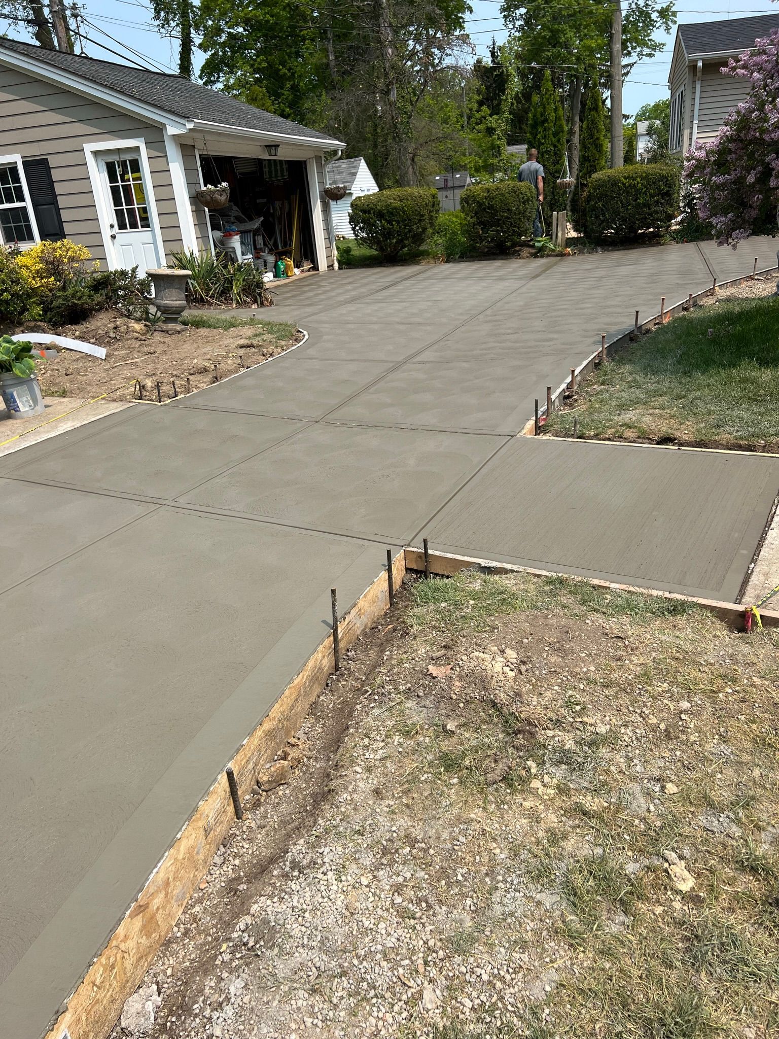 A concrete driveway is being built in front of a house.