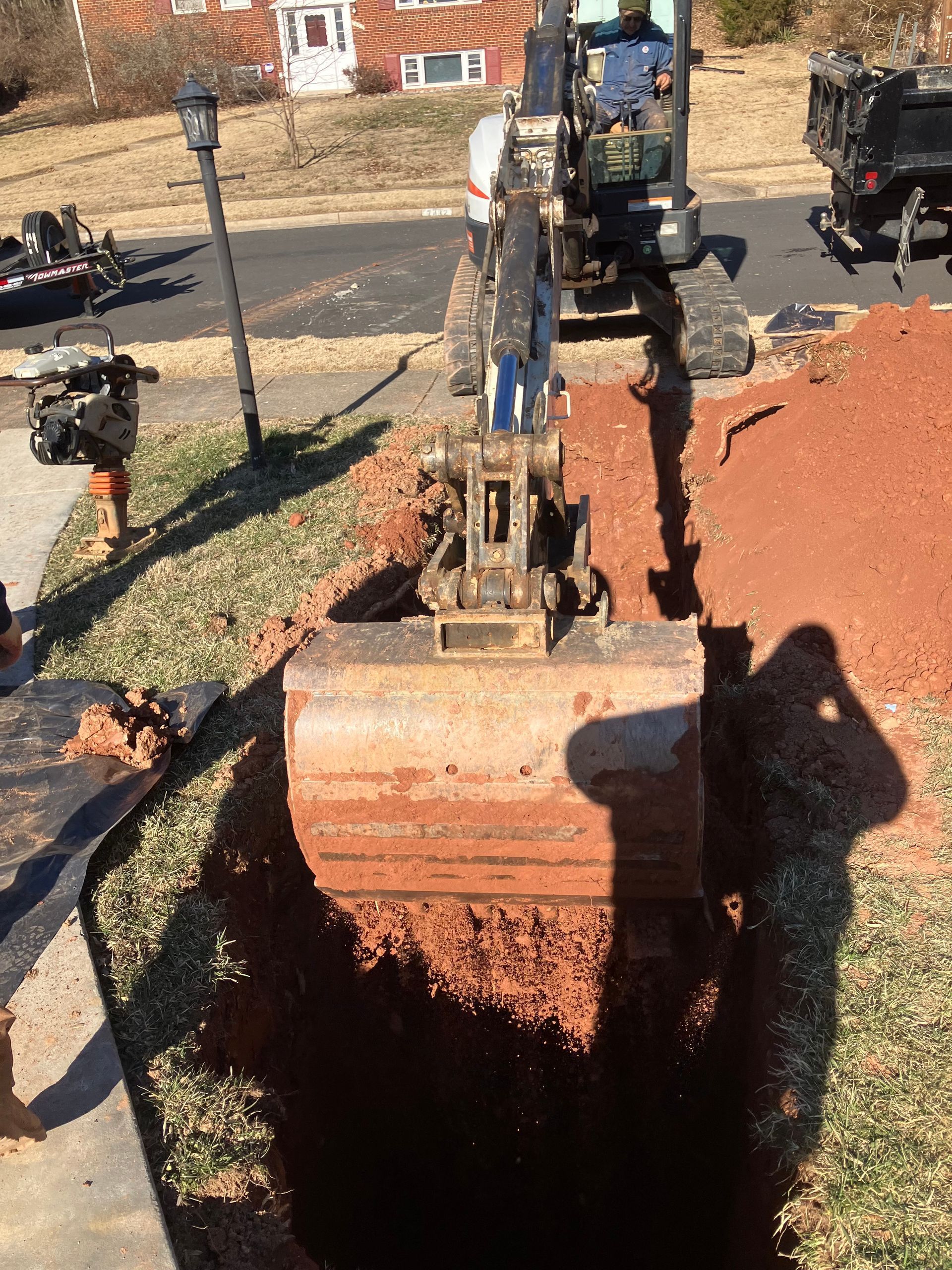 A man is driving a bulldozer through a hole in the ground.