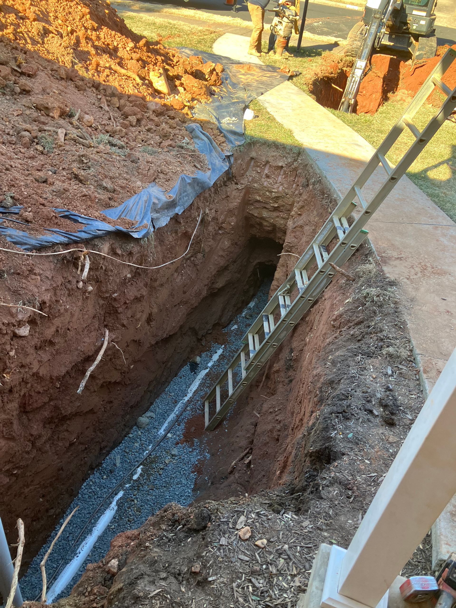 A ladder is sitting in the middle of a hole in the ground.