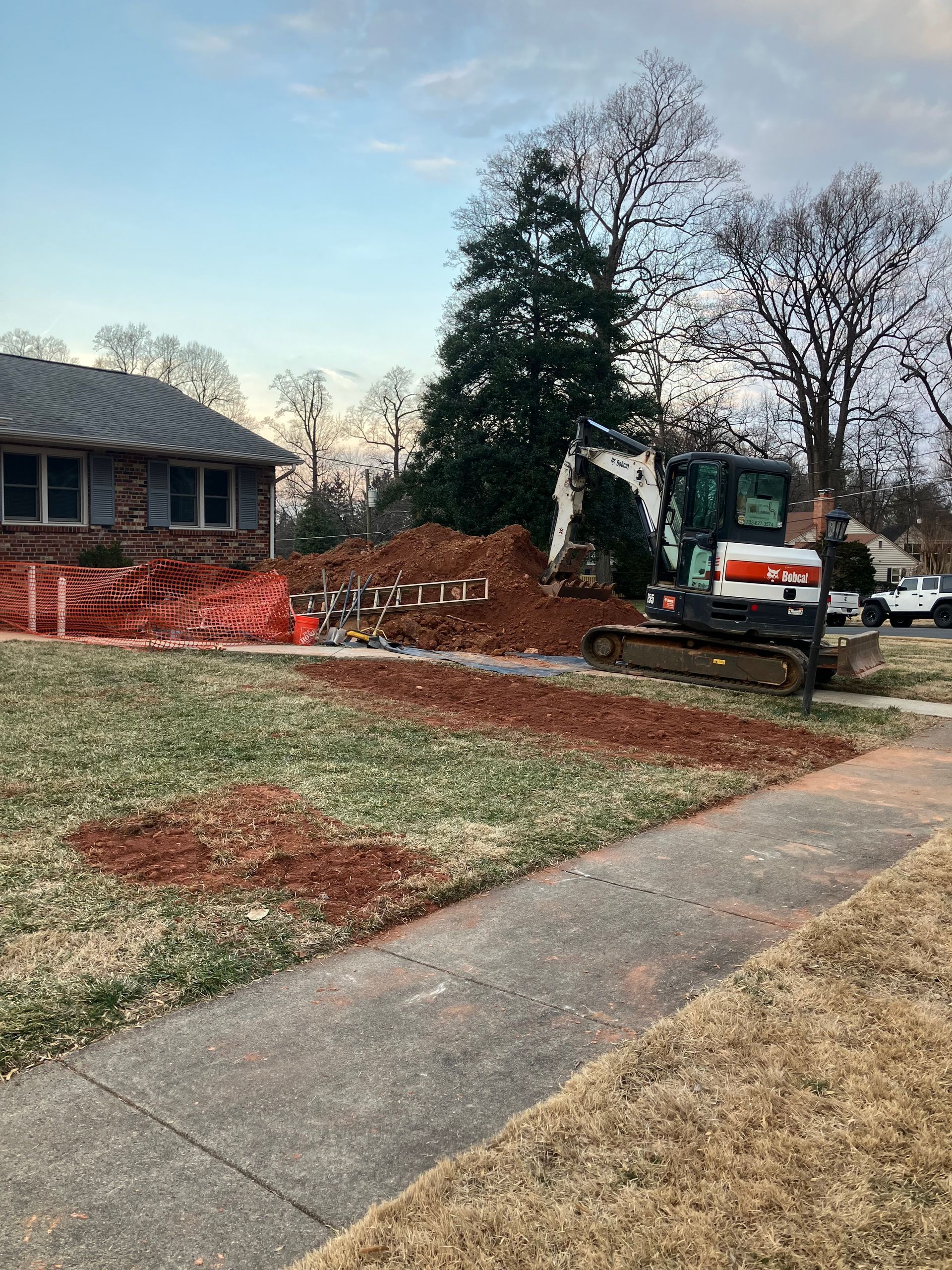 A lamp post in the middle of a lawn next to a house.