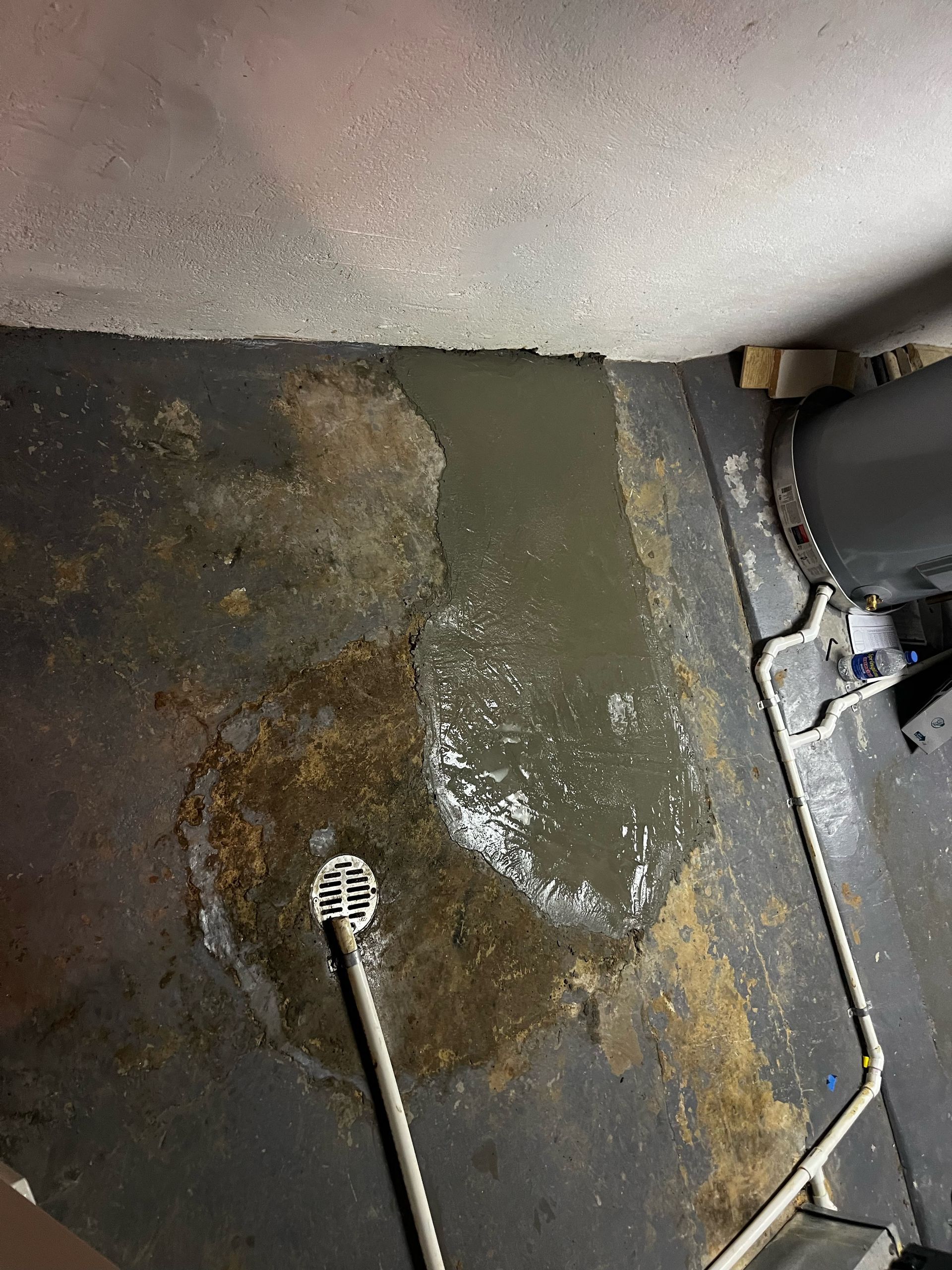 A room with a drain on the floor and water coming out of it.