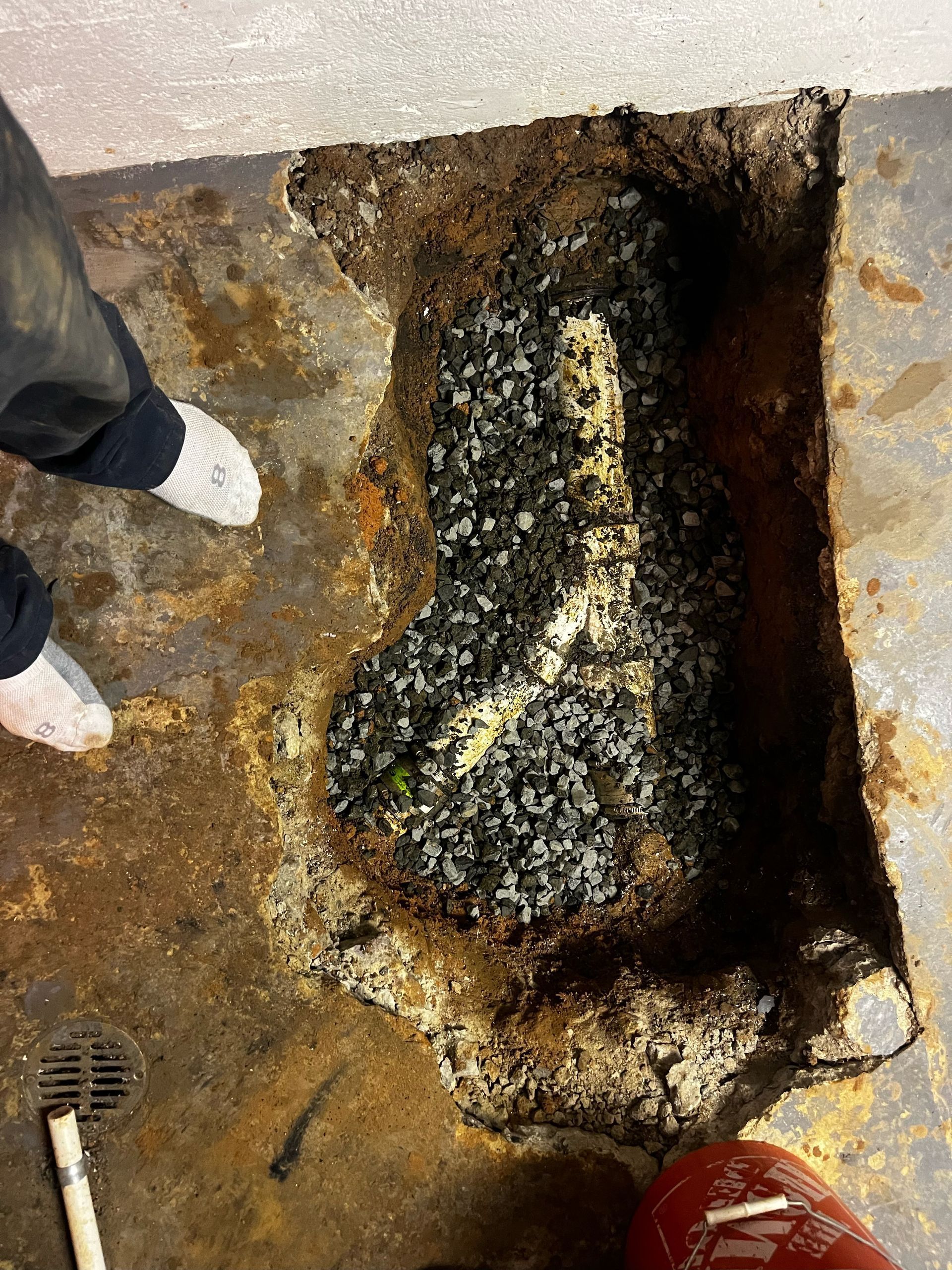 A person is standing next to a hole in the ground.