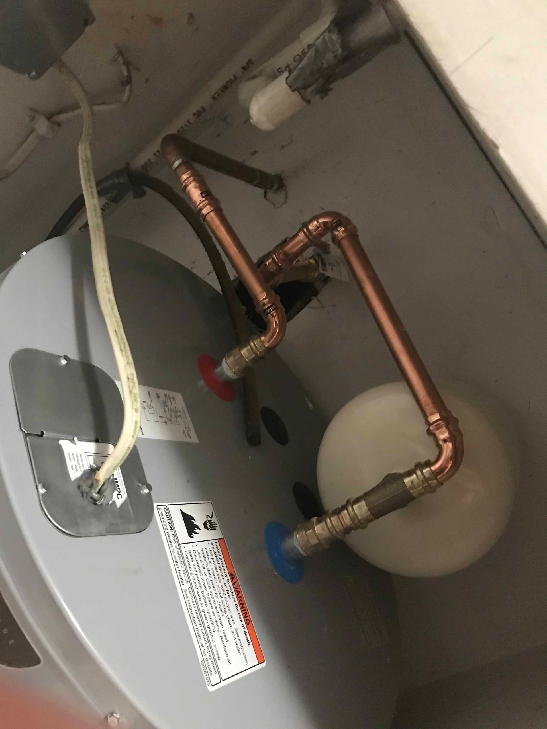 A water heater with copper pipes attached to it