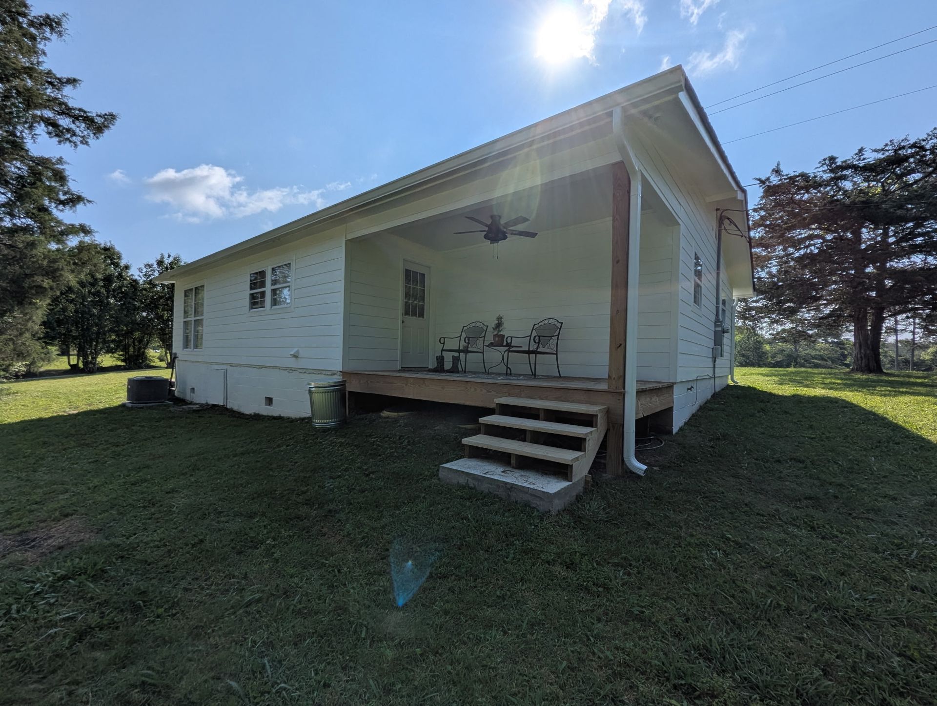 A small white house with a porch and stairs.