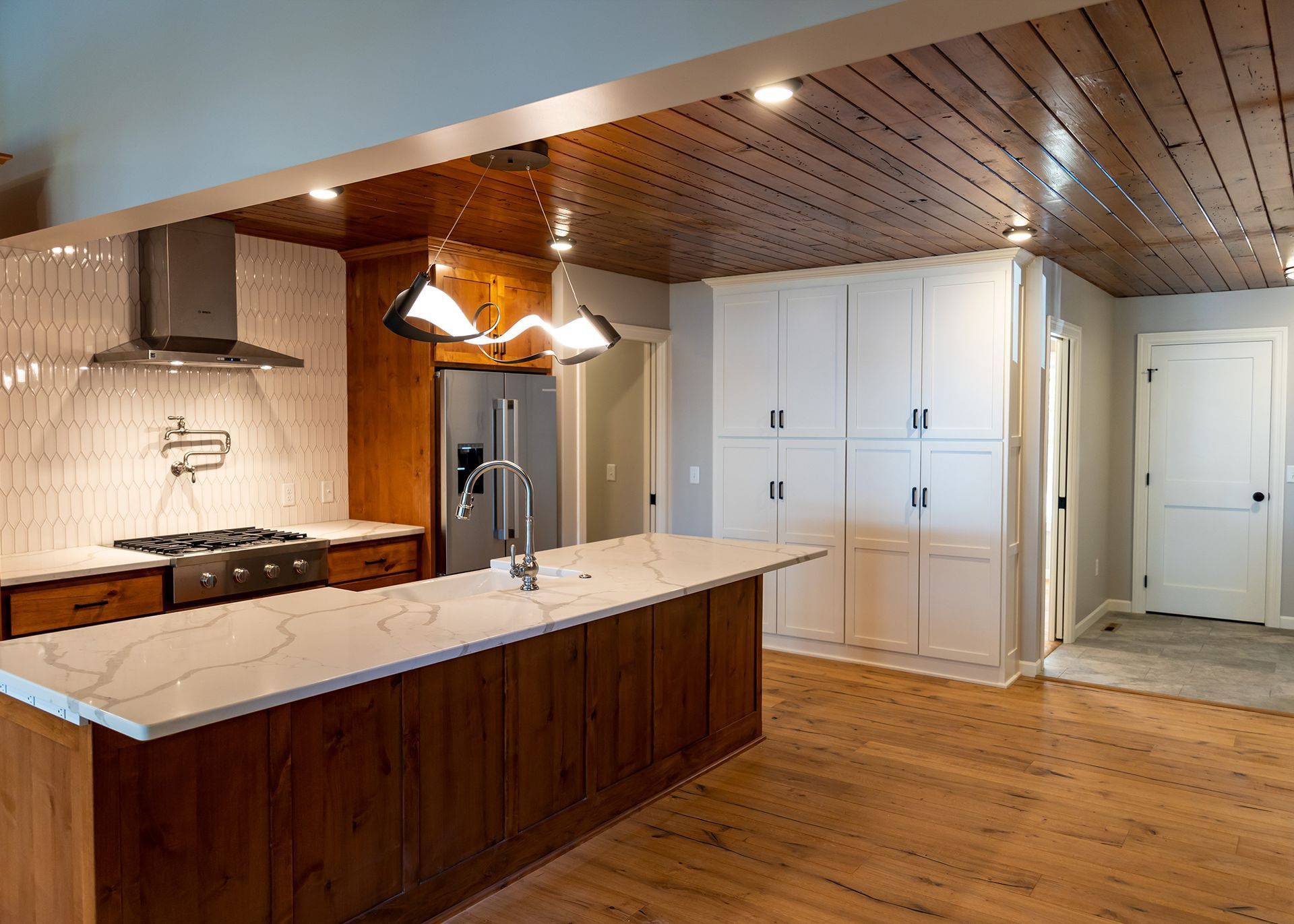 A kitchen with wooden cabinets and white counter tops