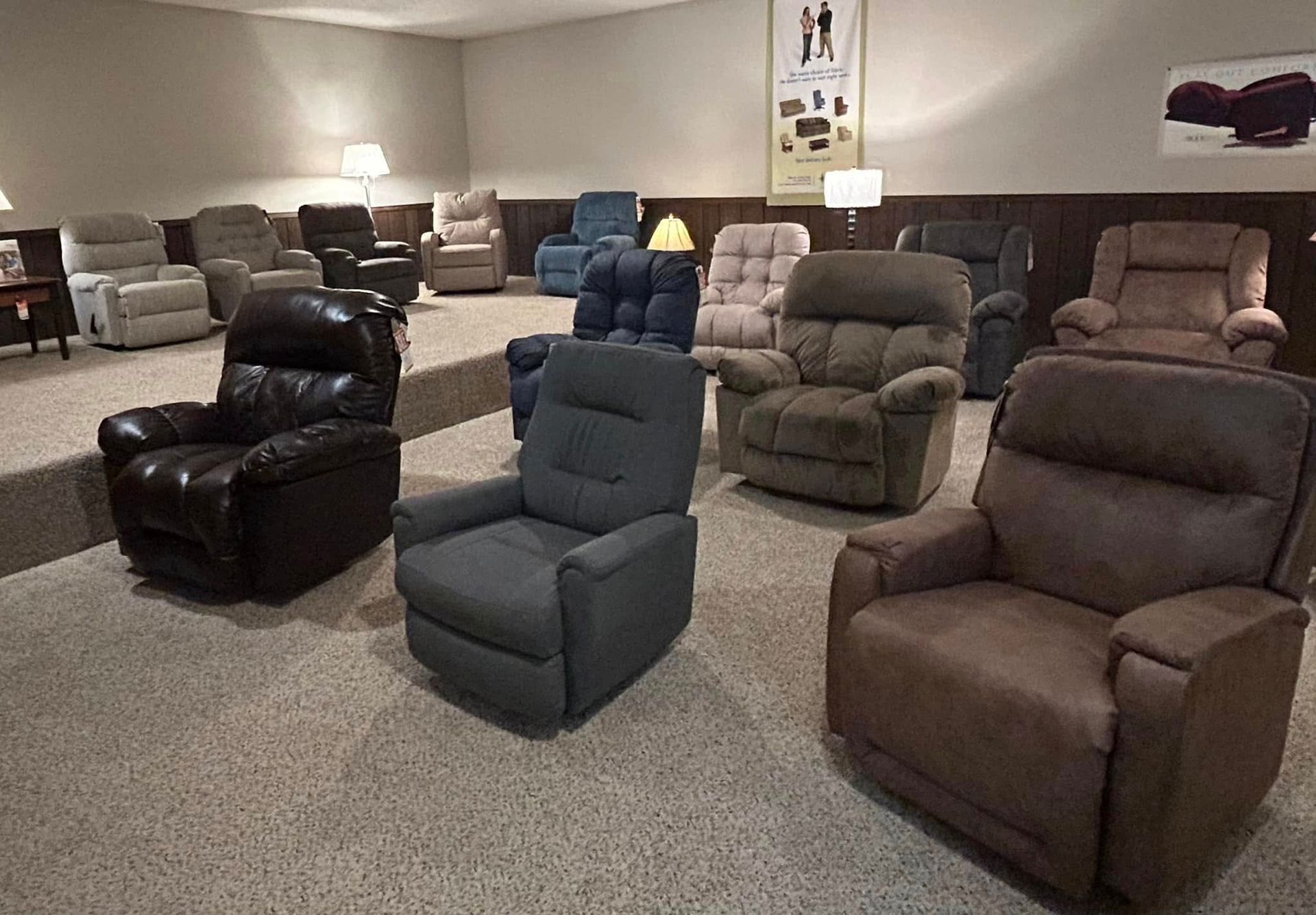 Recliner chairs in various colors displayed in a showroom setting.