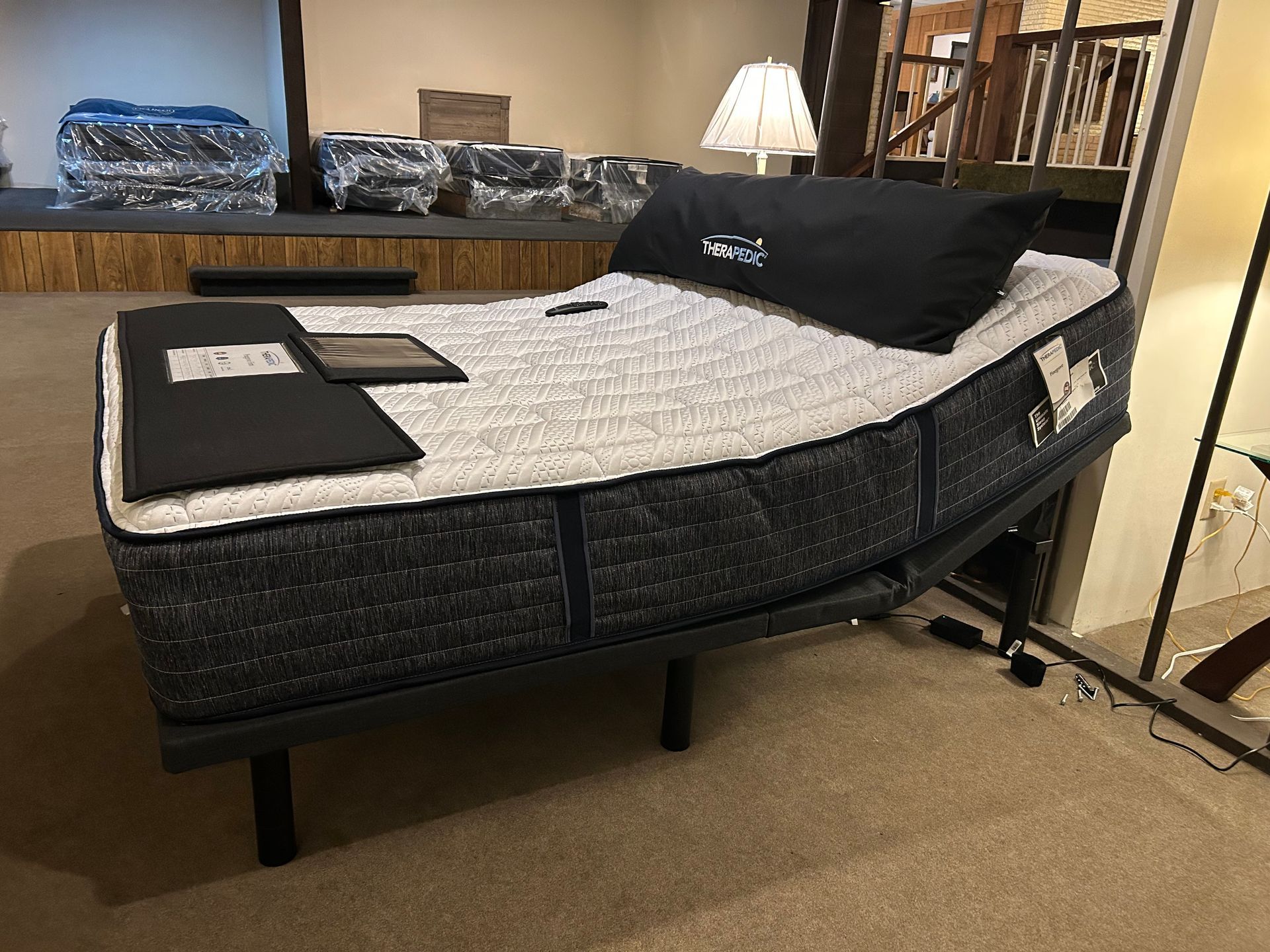 Bed with blue patterned mattress and adjustable frame, display in a store.