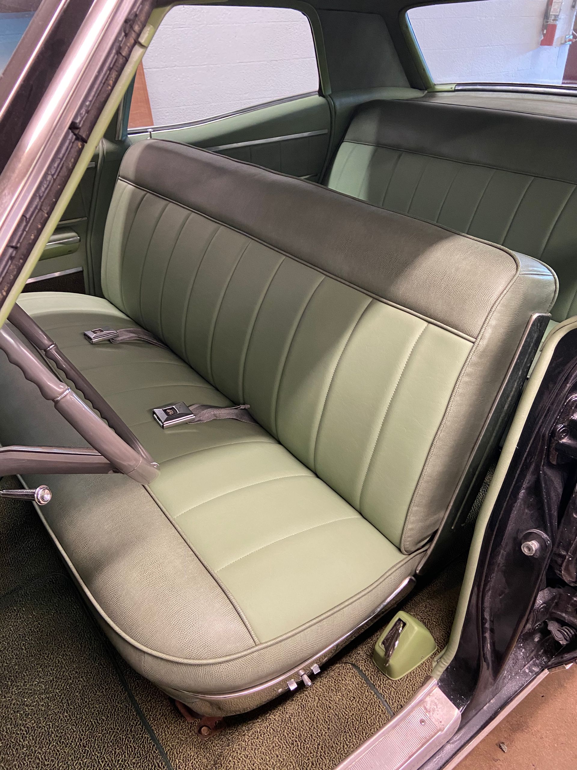 Light green and dark gray car seats inside of a classic car.