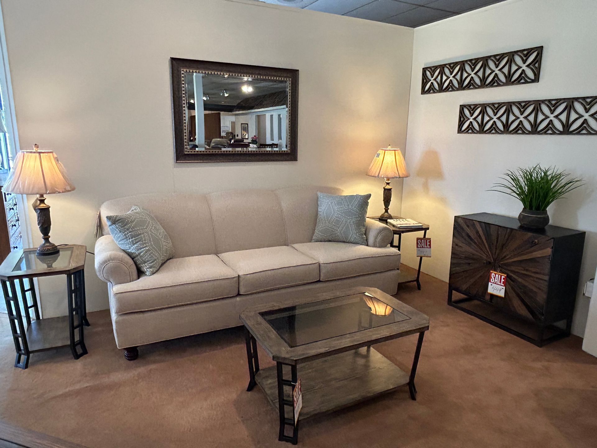 Living room furniture set with beige sofa, side tables, coffee table, and decorative accents.