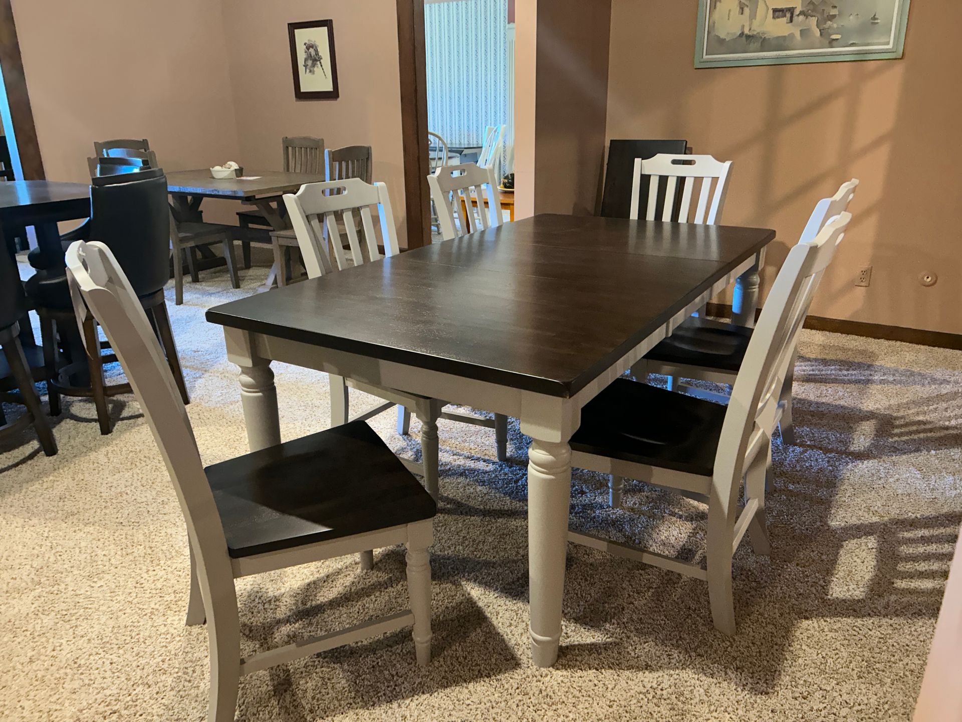 A dining table with four chairs in a room with a patterned floor.
