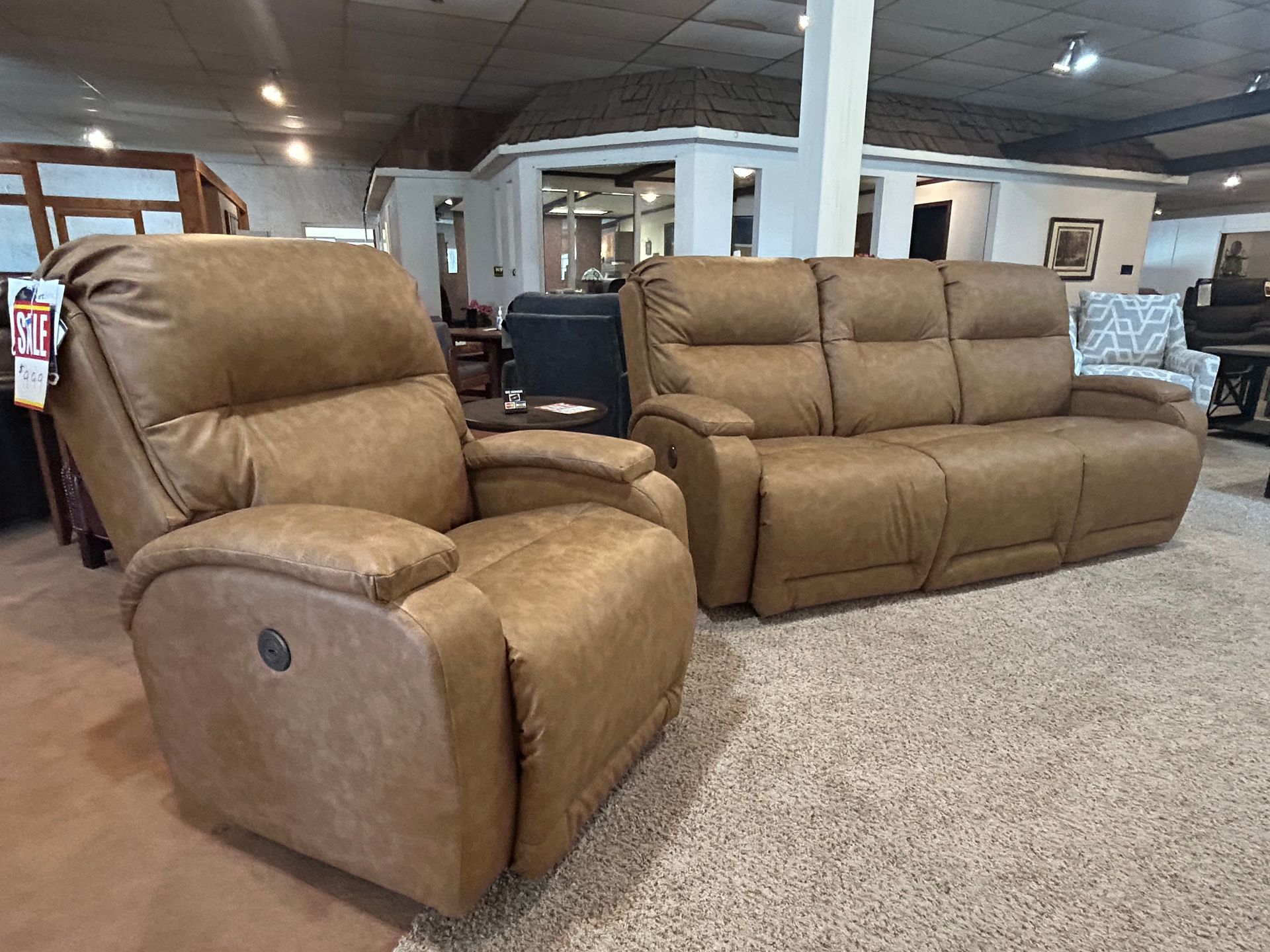 Brown leather recliner and sofa in a furniture showroom.