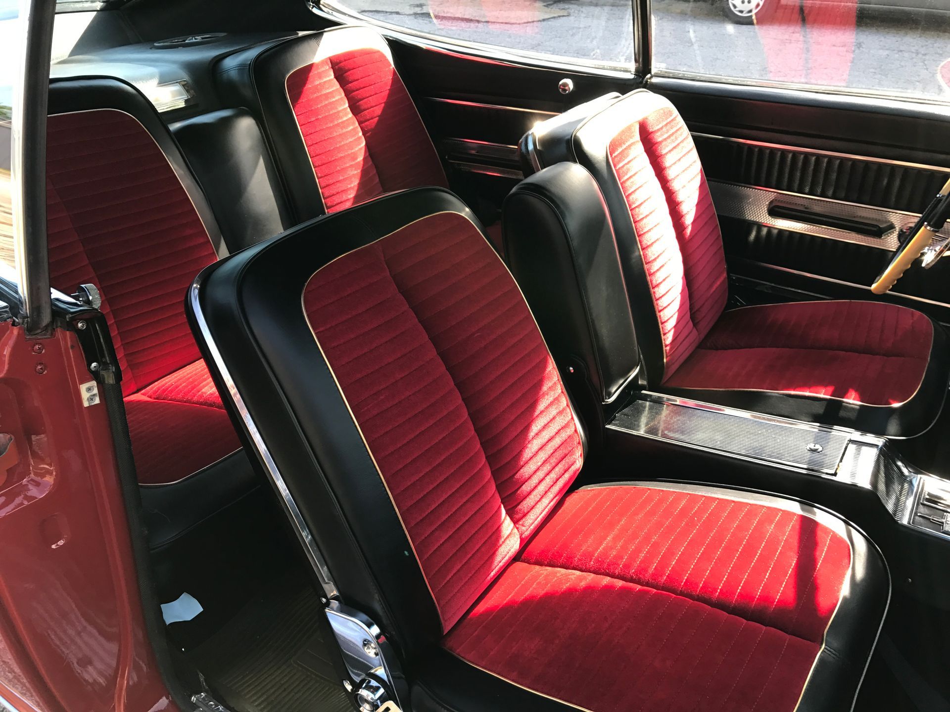 Red and black car interior with four bucket seats; console in between.