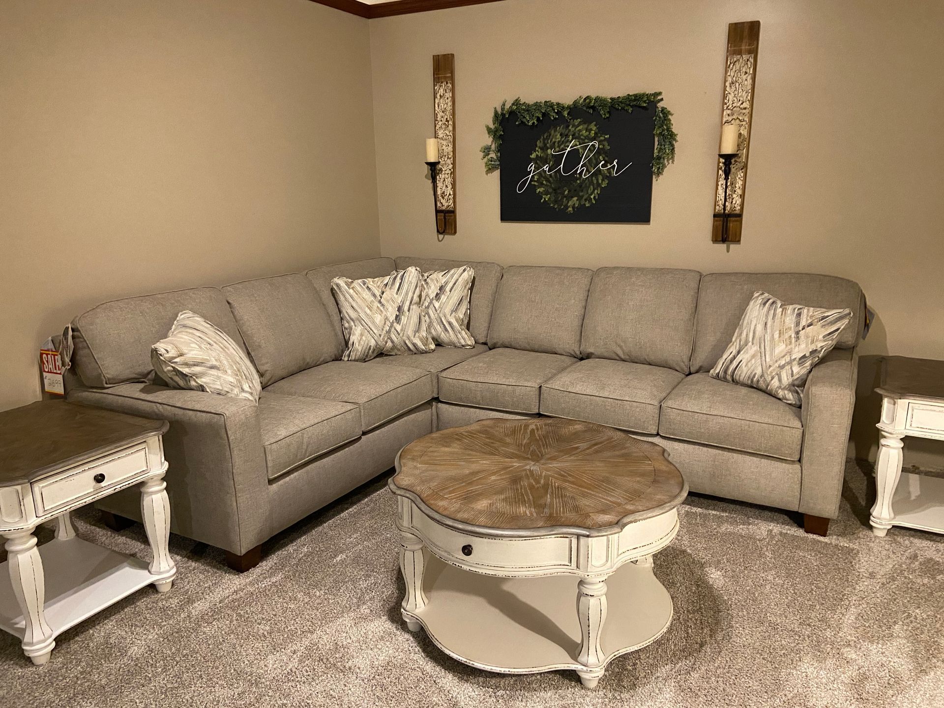 Beige sectional sofa in a living room, with side tables and a coffee table.