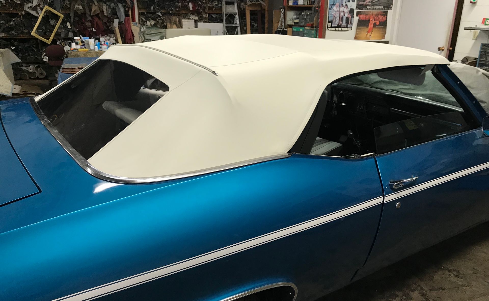 Blue classic car with a white convertible top.