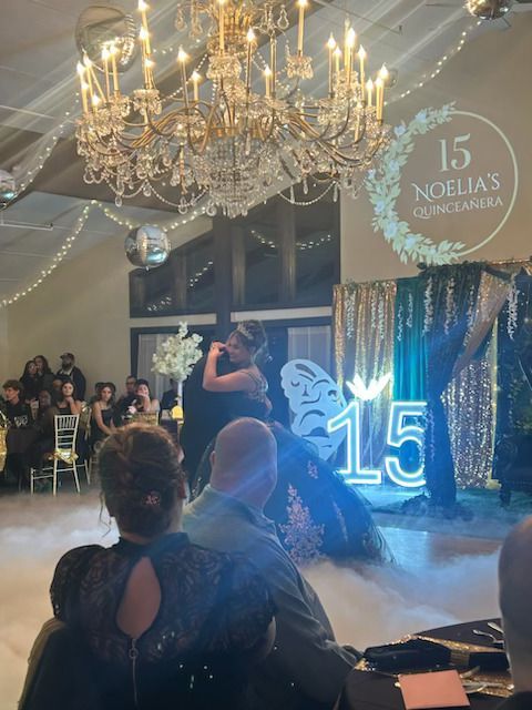 A man and woman are dancing in front of a sign.