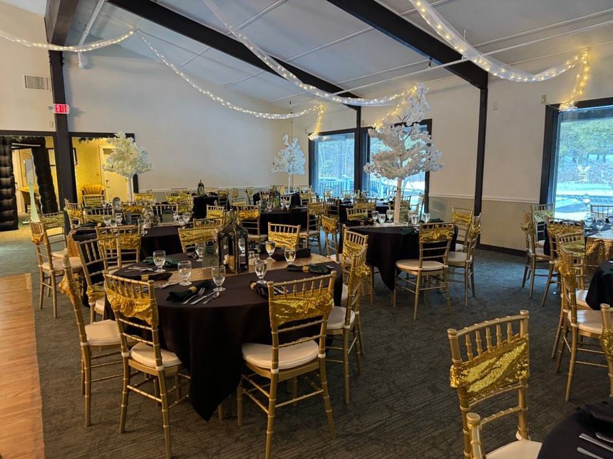 A large room with tables and chairs set up for a wedding reception.