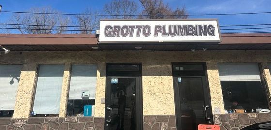 A building with a sign that says grotto plumbing