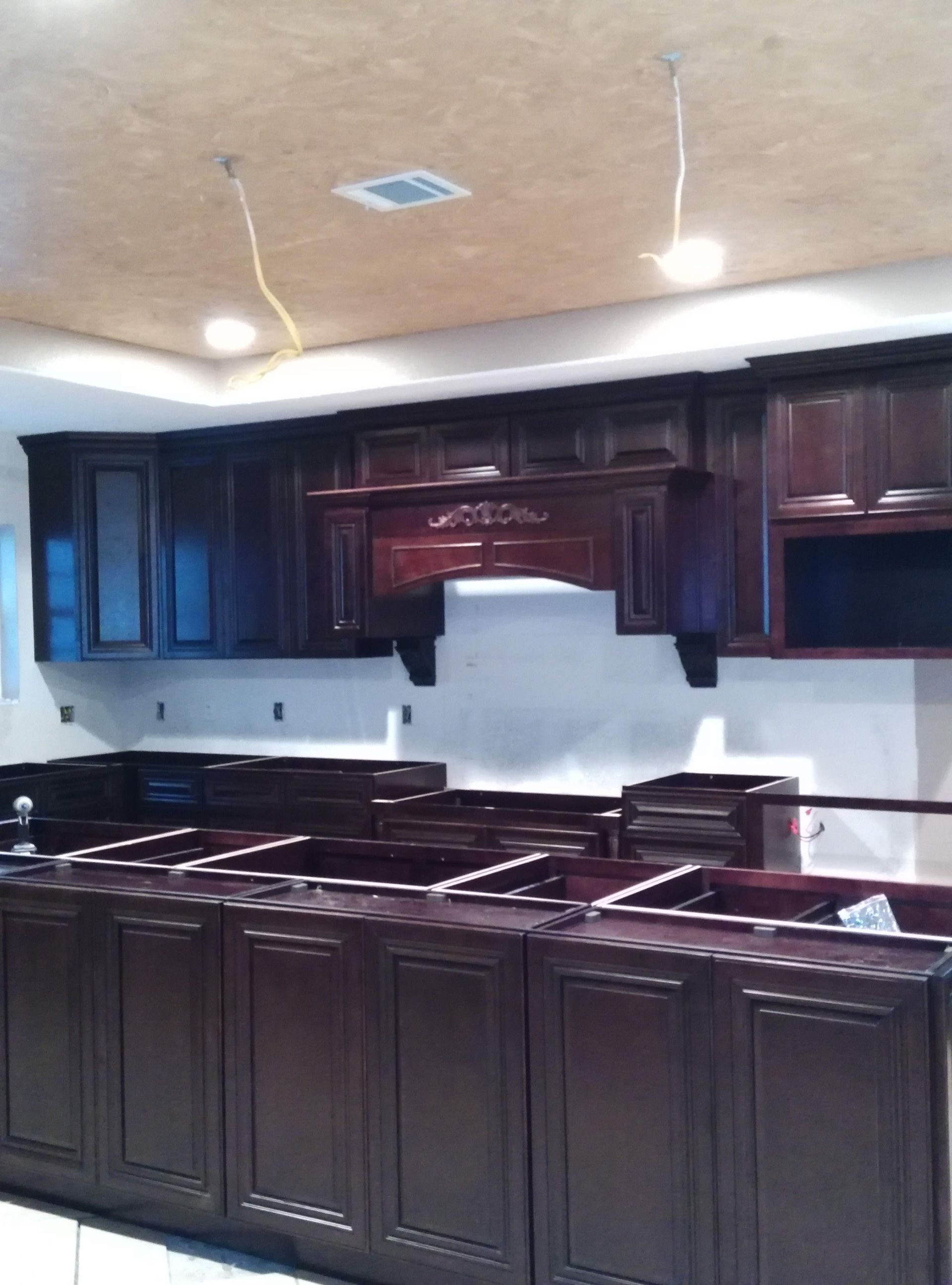 A kitchen with a lot of cabinets and a ceiling fan