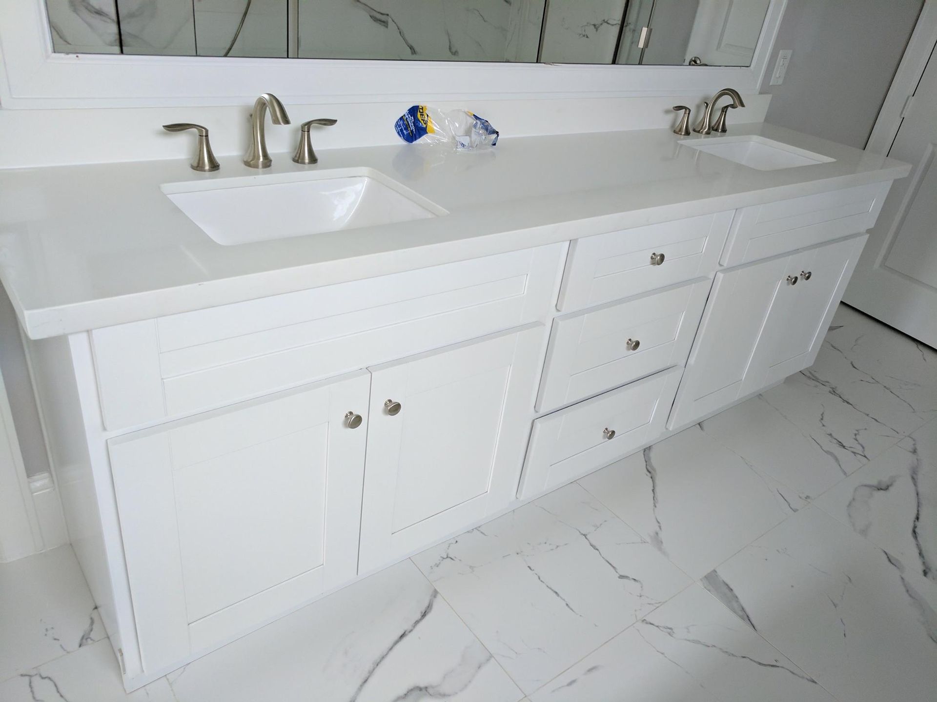 A bathroom vanity with two sinks and a mirror.