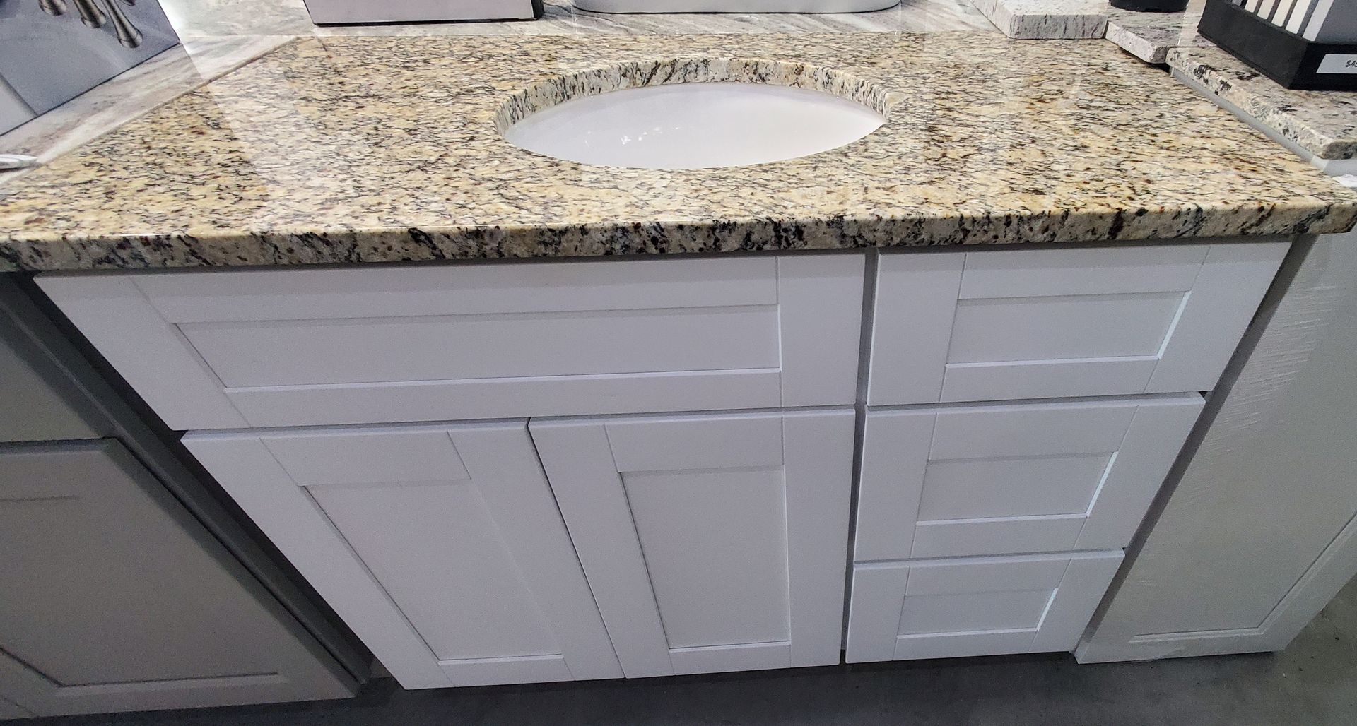 A bathroom vanity with a sink and granite counter top.