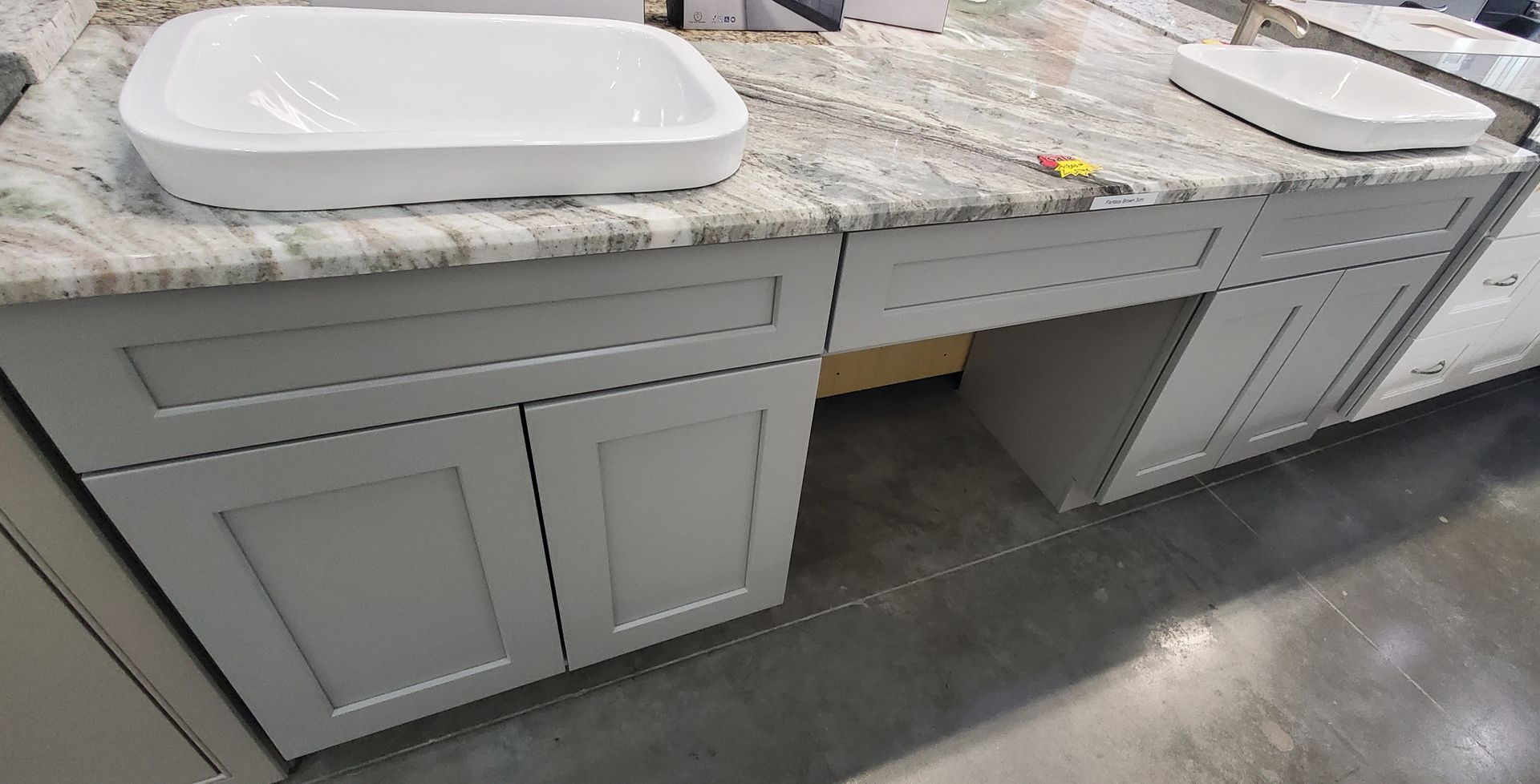 A bathroom vanity with two sinks and a granite counter top.