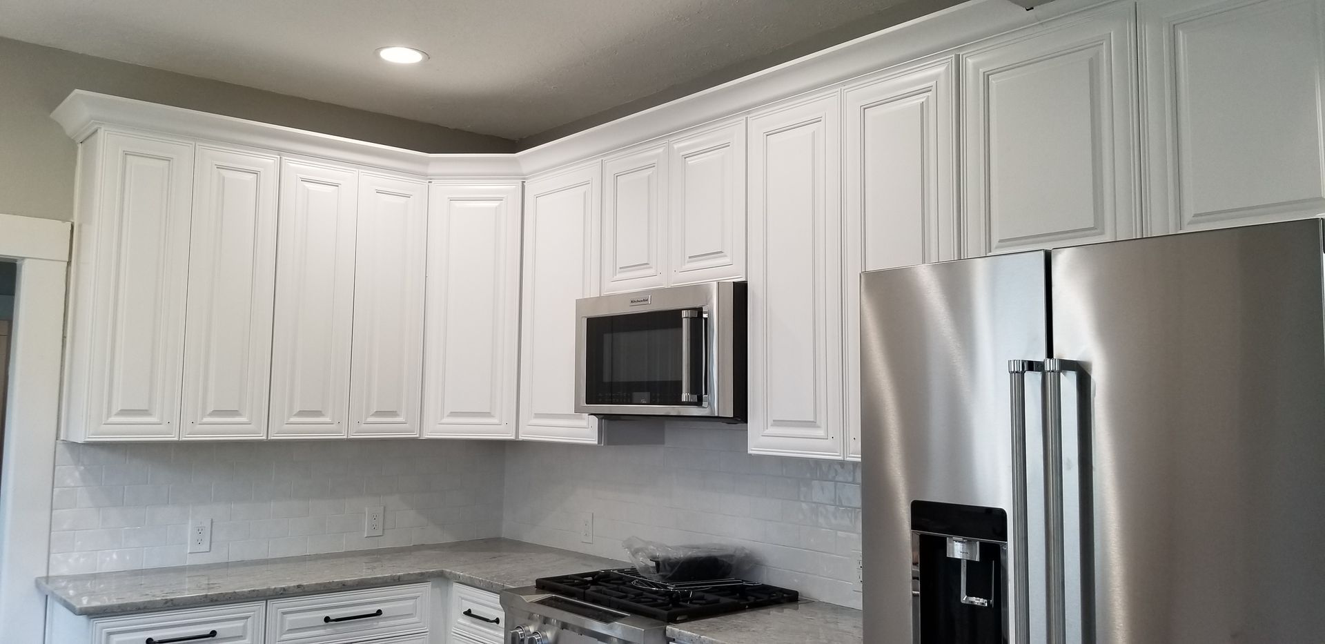 A kitchen with white cabinets and stainless steel appliances.