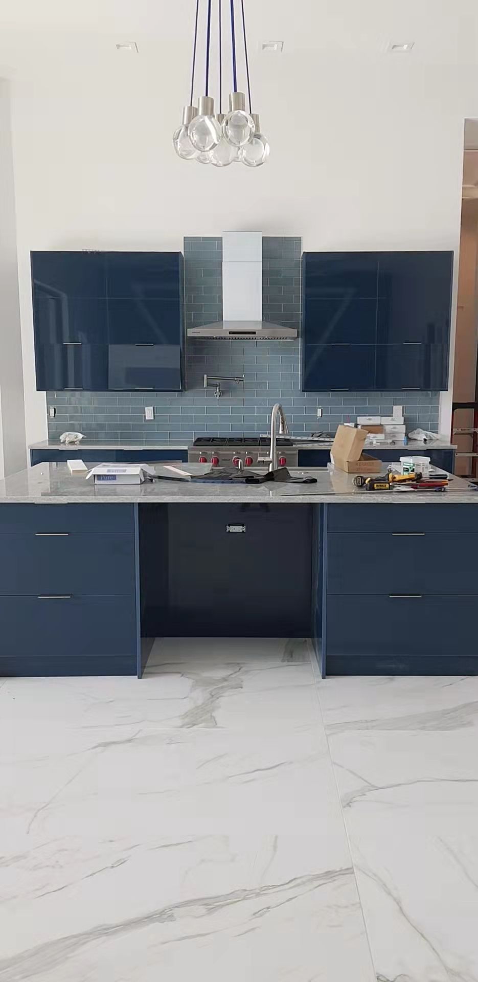 A kitchen with blue cabinets and a white counter top.