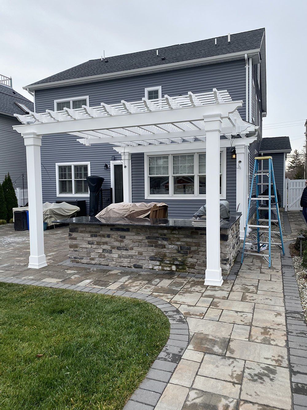 White arbor and gray house