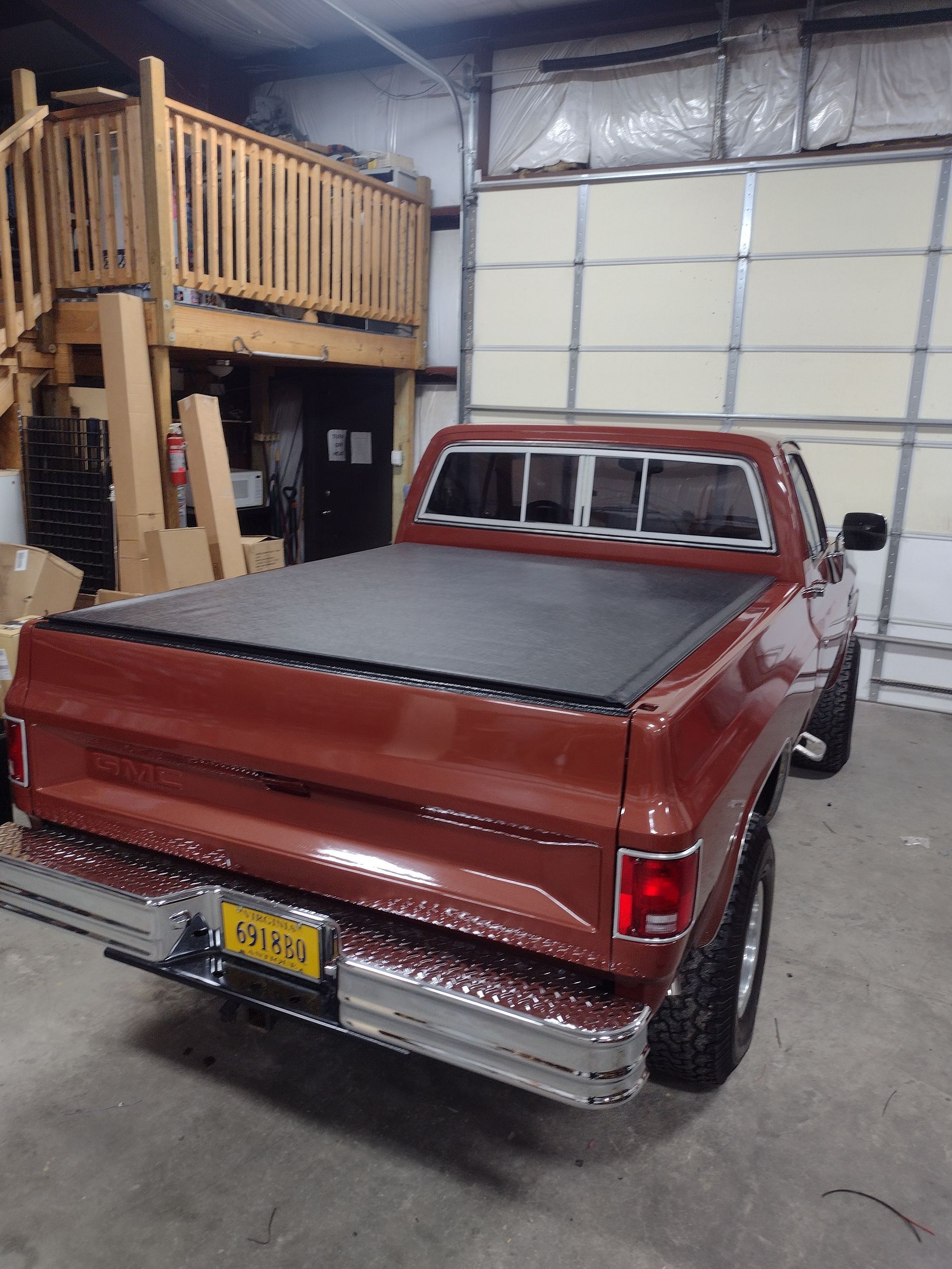 Brown Chevy pickup truck inside a garage with a loft.