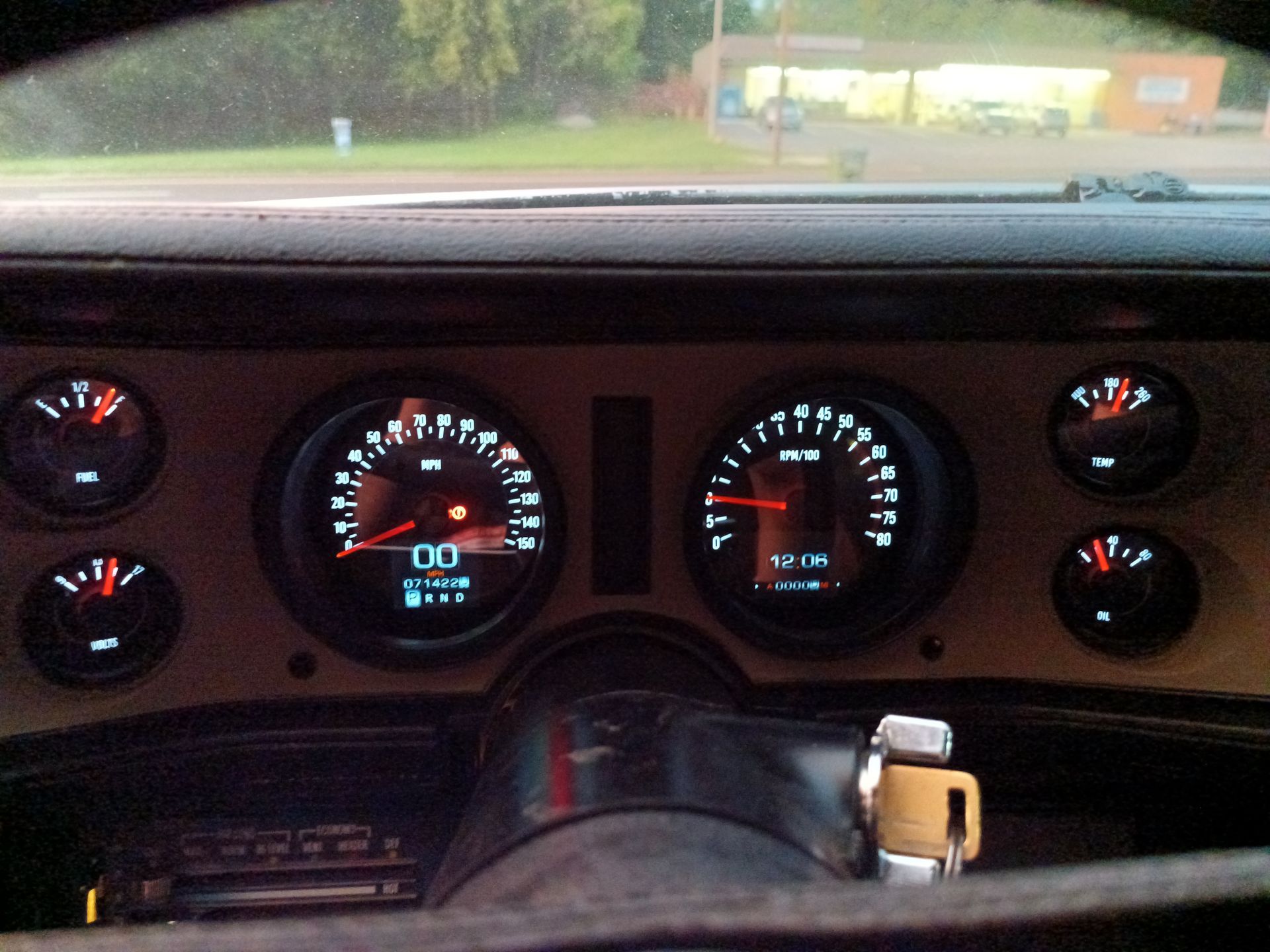 Dashboard with illuminated gauges displaying speed, RPM, fuel level, and other information in a classic car.