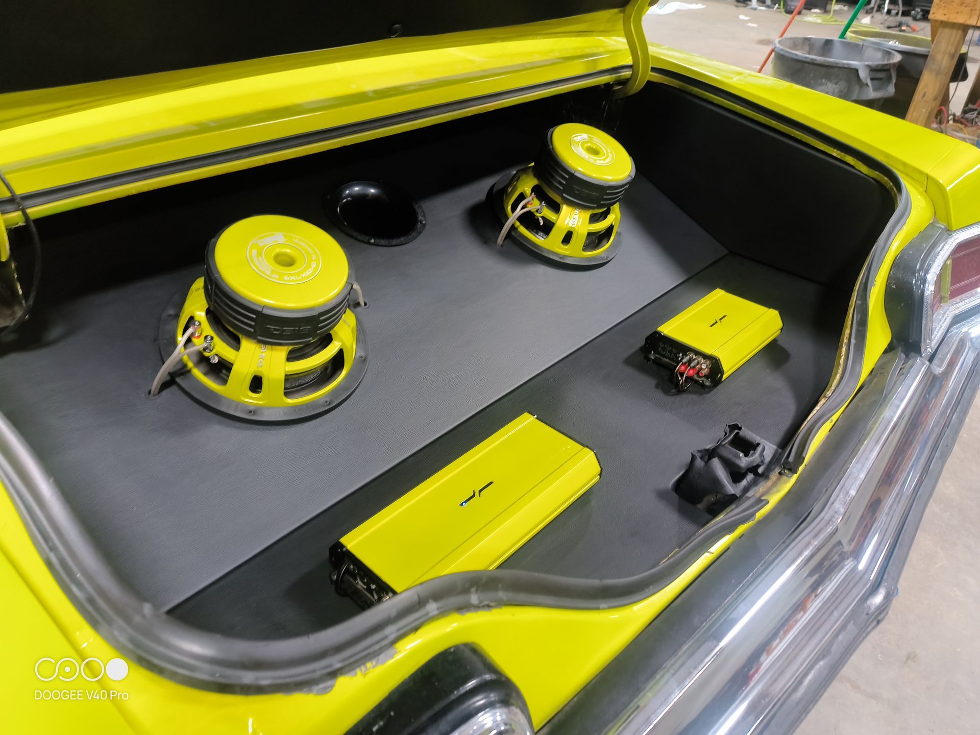 Yellow car trunk with audio system: speakers and amplifiers.