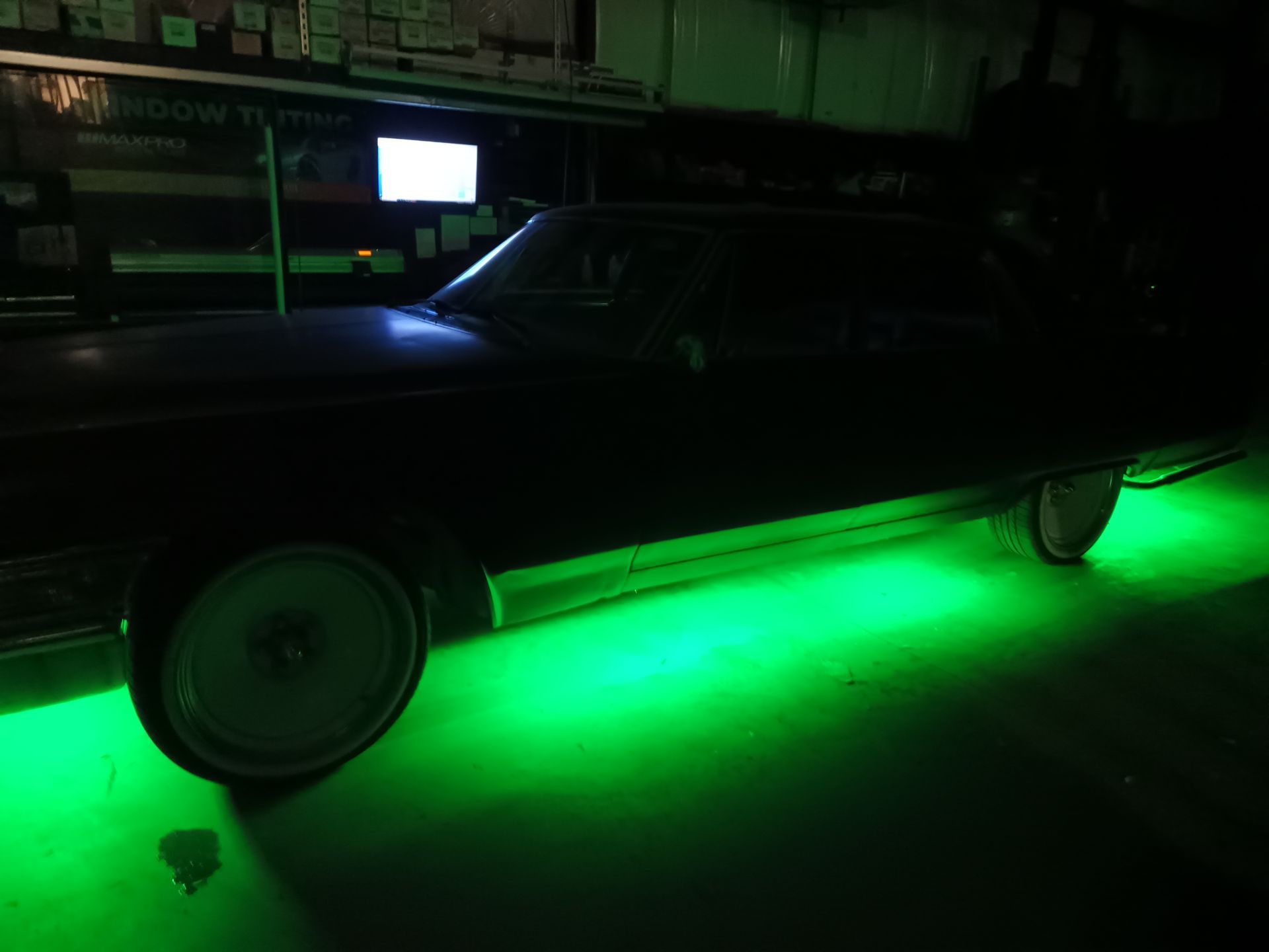Dark car with green underglow lights.